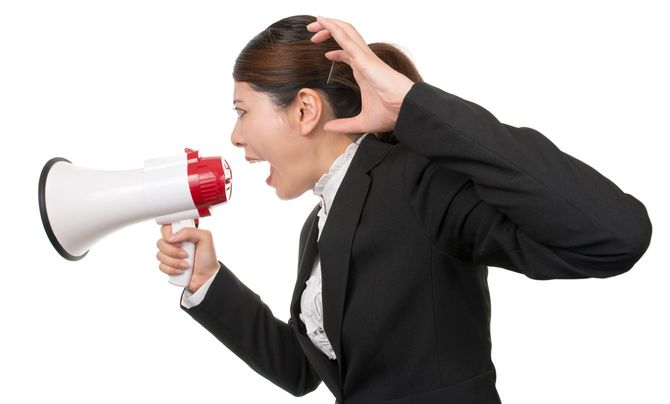 メガホンで叫んでいるスーツの女性