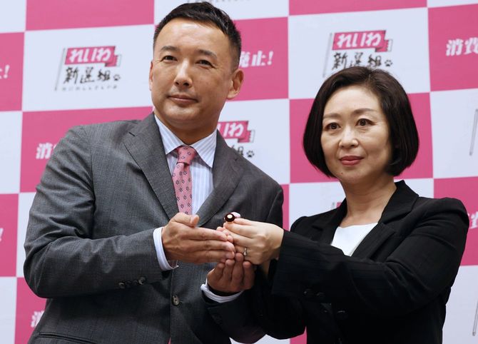 記者会見を終え、櫛渕万里氏（右）に議員バッジを手渡し撮影に応じる、れいわ新選組の山本太郎代表＝2022年4月15日、東京・永田町の衆院議員会館