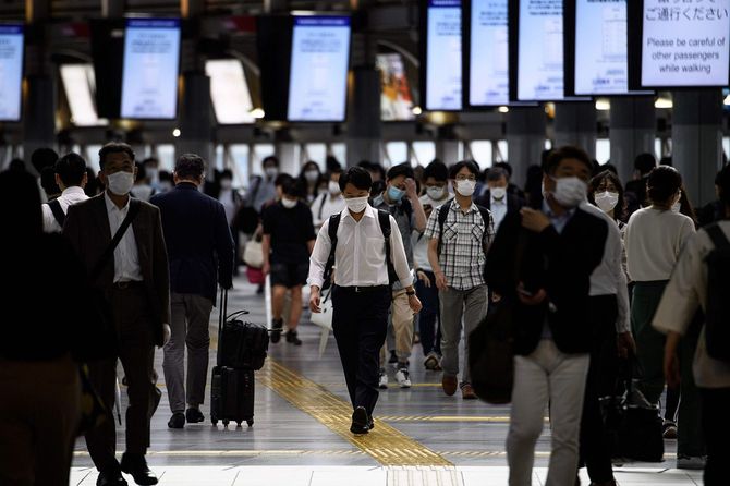 2020年6月24日、東京・品川駅。帰宅ラッシュの時間帯に、マスクをつけた人々が歩いている。