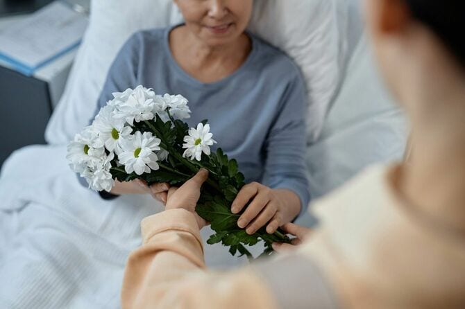病院で病気の母親を見舞う娘