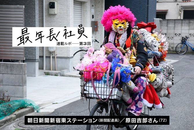 ピンクアフロのカツラにタイガーのお面をして自転車に乗る人