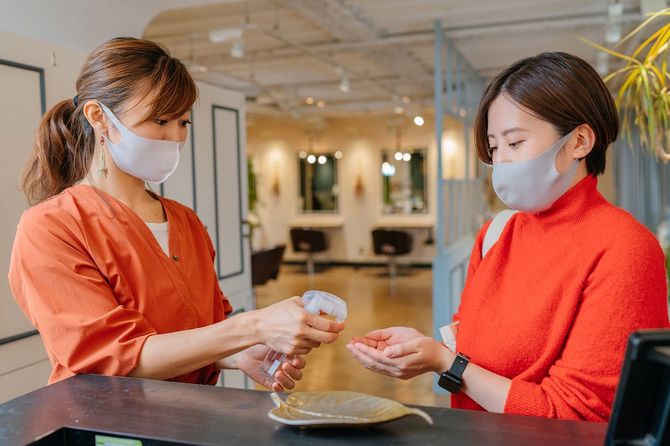 手に消毒剤を吹き付ける