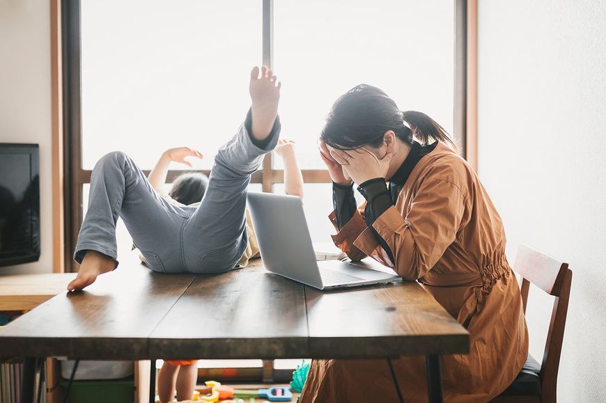 遊ぶ子どもと仕事が手につかない大人のイメージ