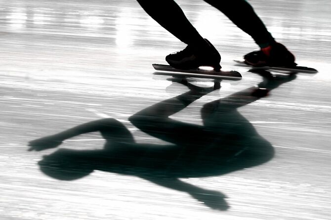 スピードスケート選手の足元と影