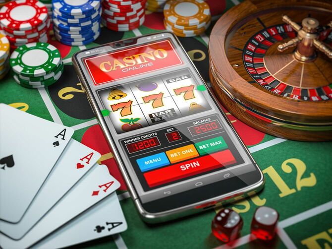 トランプやルーレットなどカジノで使用する道具とオンラインカジノが表示されたスマホ