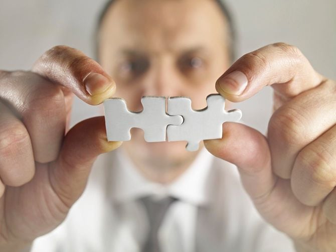 2つのパズルピースを合わせる人