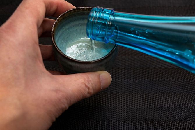 おちょこに日本酒を注ぐ人の手元