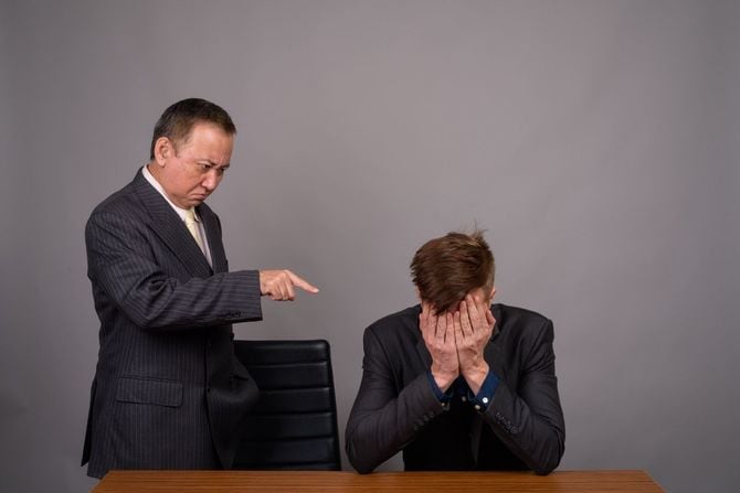 指摘する上司と落ち込む部下の男性