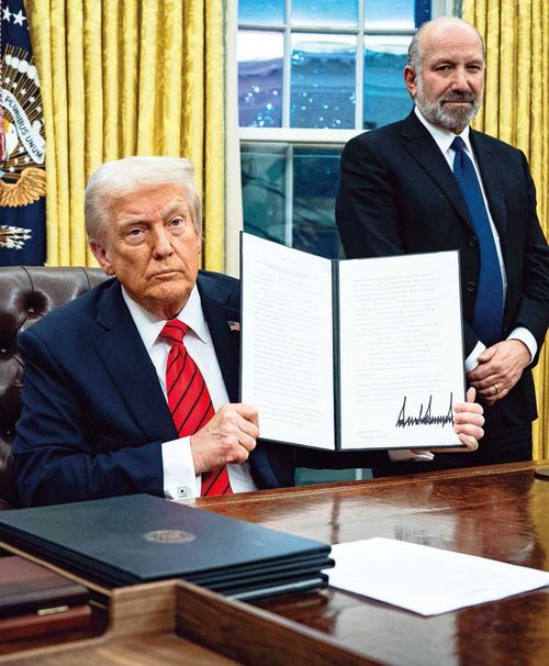 ドナルド・トランプ氏が行政命令を掲げる様子