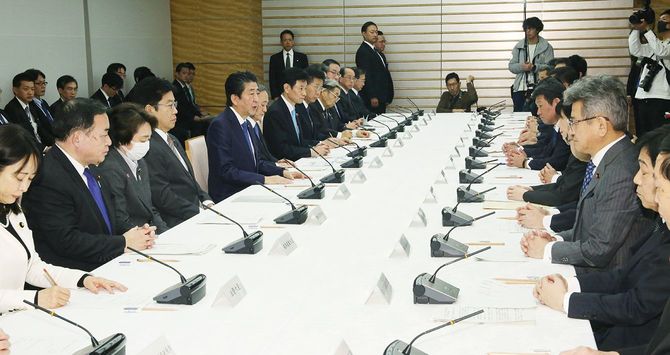 新型コロナウイルス感染症対策本部の会合で発言する安倍晋三首相（左手前から5人目）＝2020年3月7日、首相官邸
