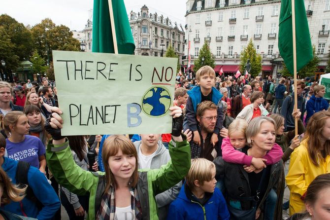 2014年9月21日、地球の気候変動に対する行動を支援するためにノルウェーのオスロ中心部を行進する数千の人々