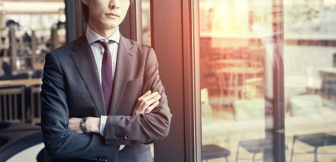 窓によりかかるビジネスマン