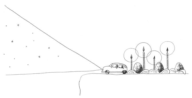 車のヘッドライトで照らされる雪