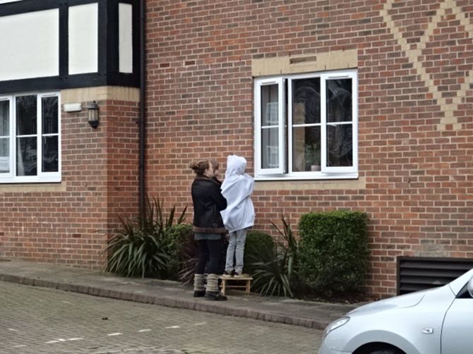 介護施設の入居者と面会する家族。同居していない家族が屋内で会うことは禁止されているため、ガラス越しに話しかけている。