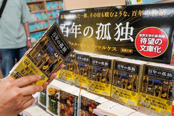 コロンビアの作家ガブリエル・ガルシア＝マルケスの『百年の孤独』（文庫版）を手にする書店員＝2024年6月26日、東京・紀伊國屋書店本店