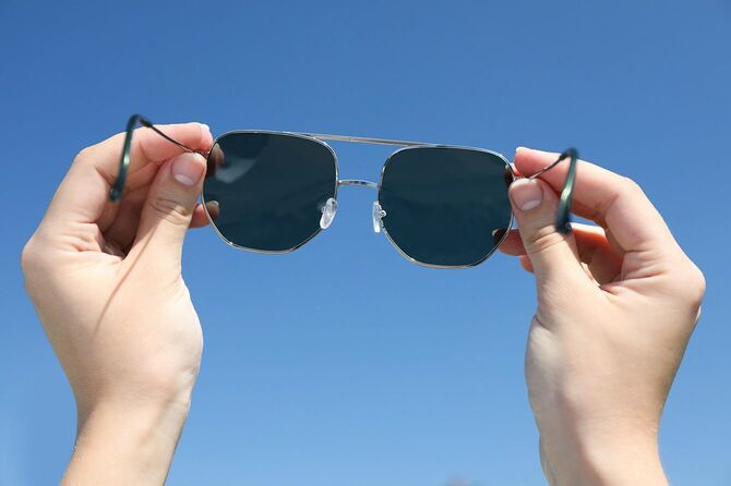 サングラスを持つ手