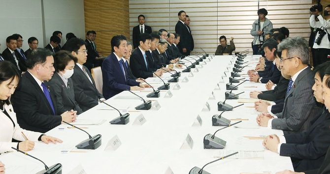 新型コロナウイルス感染症対策本部の会合で発言する安倍晋三首相(左手前から5人目)=2020年3月7日、首相官邸