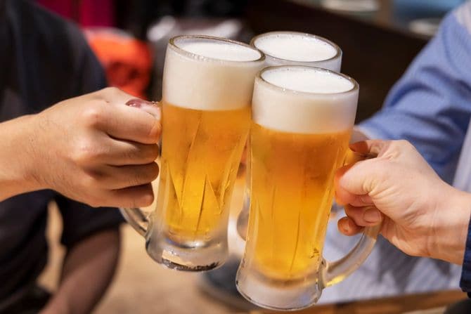 グラスビールで乾杯する人々