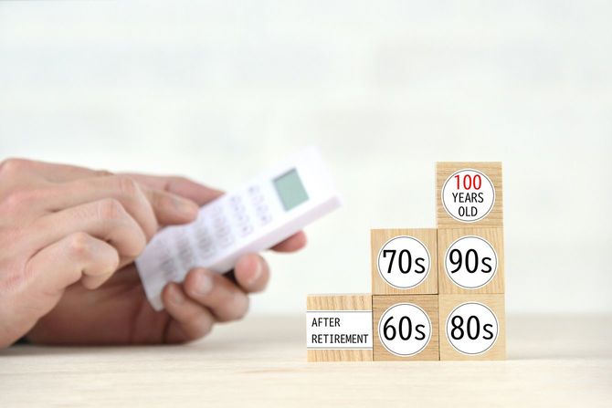 電卓と「引退後」の横に年齢層が書かれた木のブロック