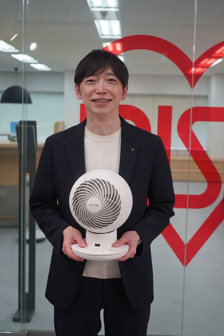 サーキュレーターを手に撮影に応じる原さん