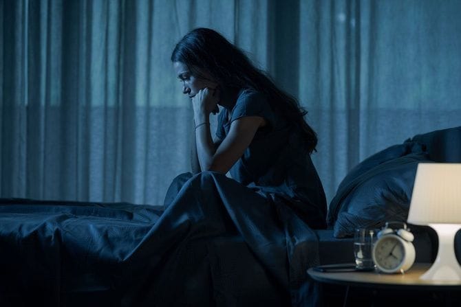 夜ベッドで目を覚ます女性