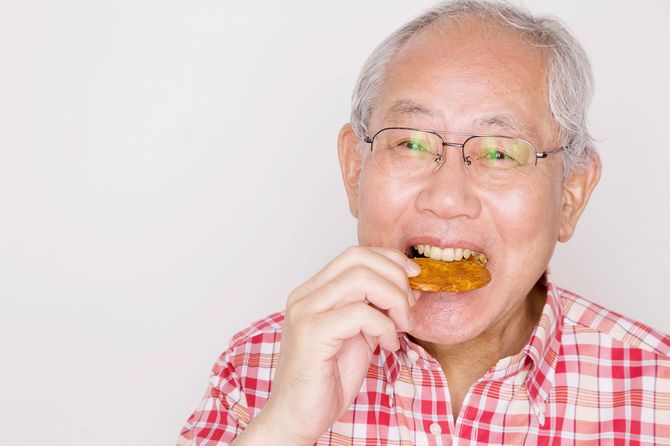 せんべいを食べる高齢の男性
