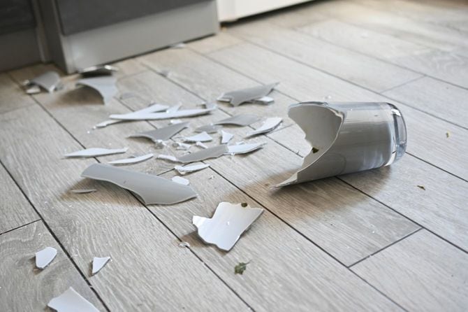 床に破片が飛び散っている割れた花瓶