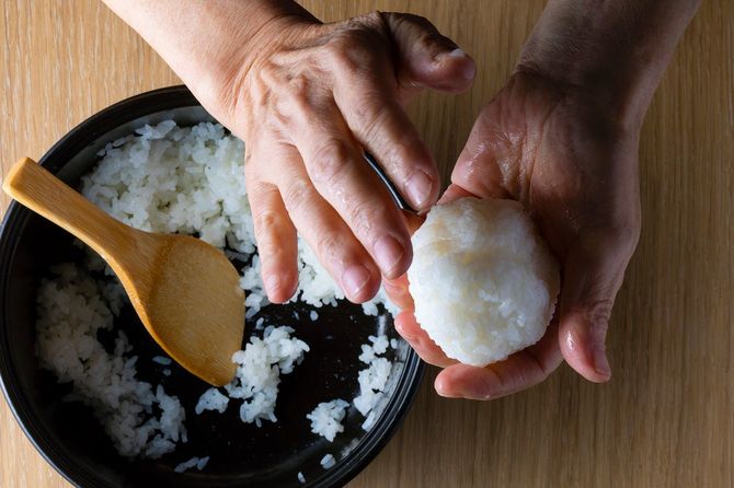 おにぎりを握る高齢女性の手