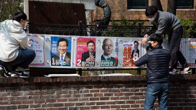 韓国・ソウルで選挙ポスターを貼る国政選挙委員会の関係者たち＝2020年4月2日、来る総選挙に向けた13日間の公式選挙運動期間が4月2日から始まった。