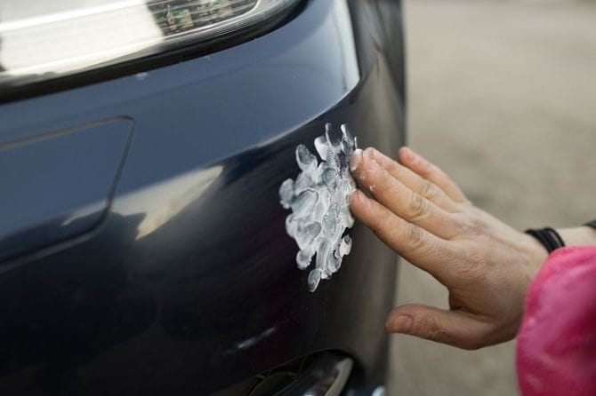 車体の軽微な傷を手動研磨している手元