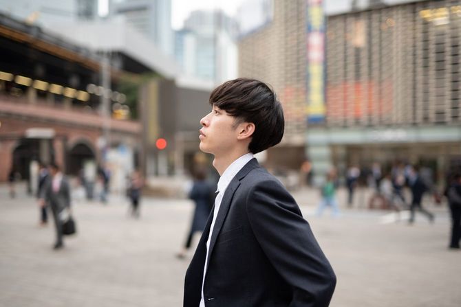 路上で誰かを待っている若いビジネスマン