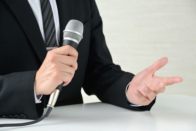 マイクを持って説明するビジネスマン