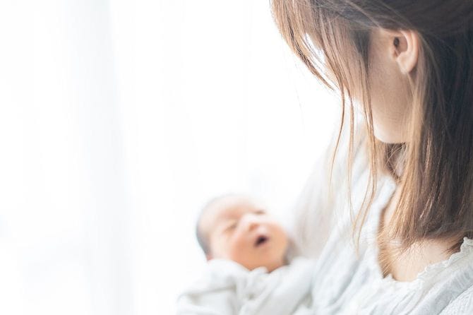 赤ちゃんを抱く母親