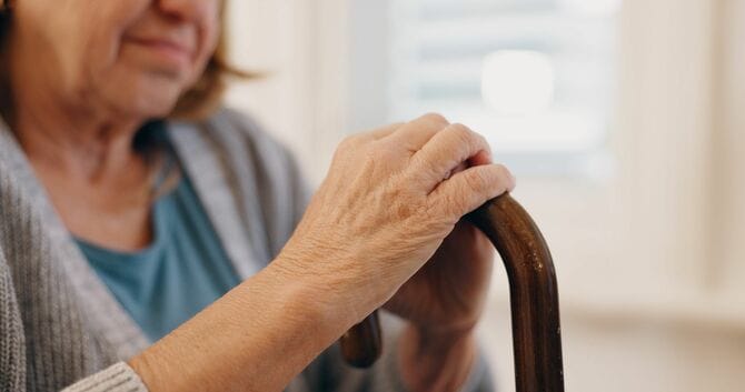 杖を持つ年配の女性