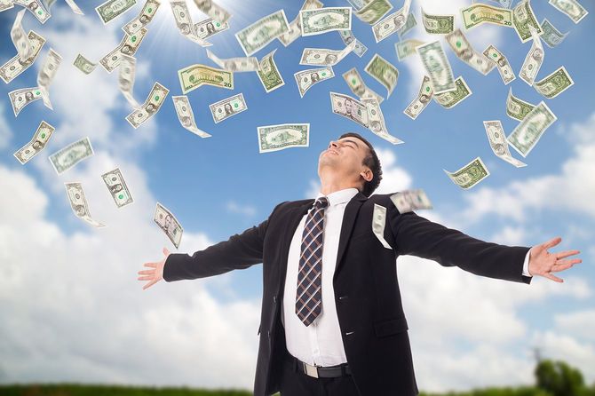 宙に舞うお札と両手を広げる男性