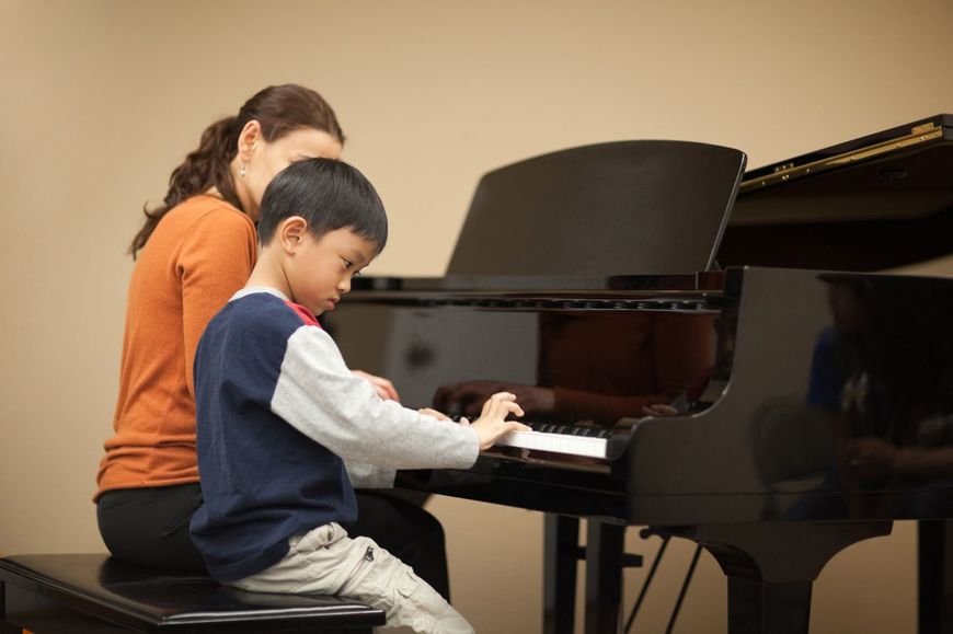 先生とピアノを弾く小さな子供