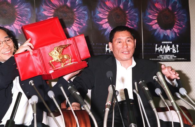 映画『HANA-BI』がベネチア国際映画祭グランプリ。金獅子賞を手に喜びを語る北野武監督。左は森プロデューサー(=1997年9月9日、千葉・成田空港)
