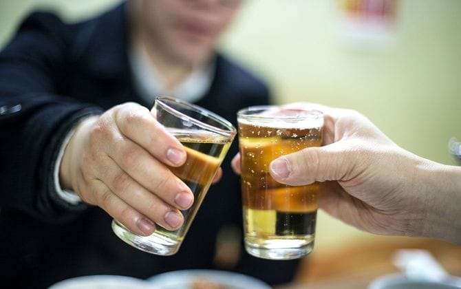 ビールで乾杯をする2人の人物