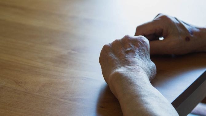 机の上に手を置くシニア