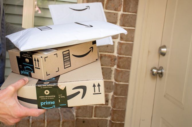 アマゾンプライムの荷物を住宅の玄関に届ける配達員
