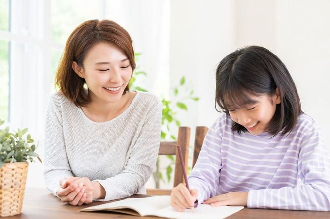 子供の勉強を見る母親