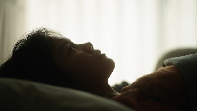 ベッドで横になる女性