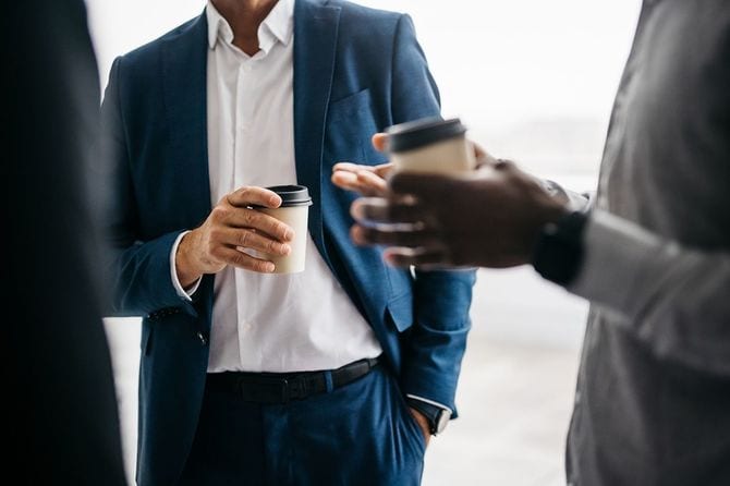 コーヒーカップを持つビジネスマンのクローズアップ