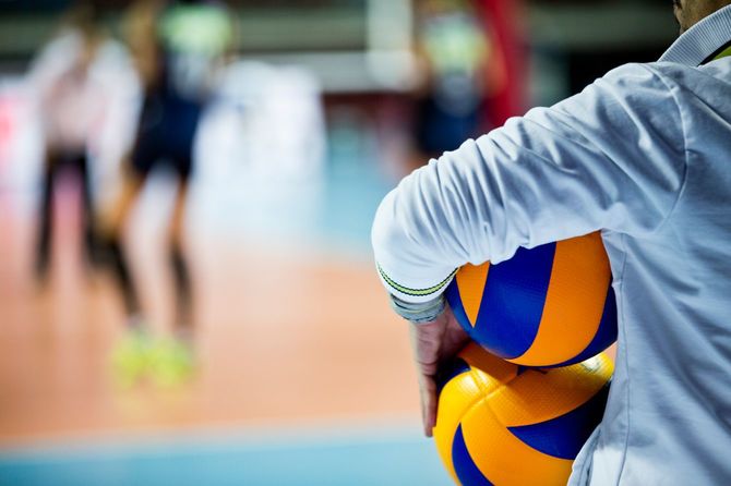 コーチとバレーボールの練習中