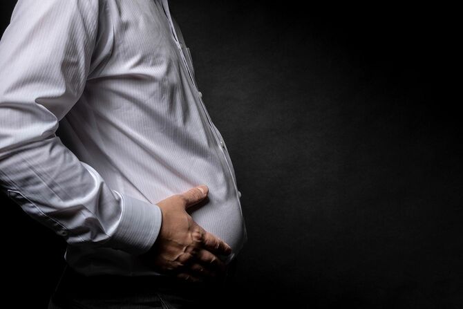 太った腹を気にする男性