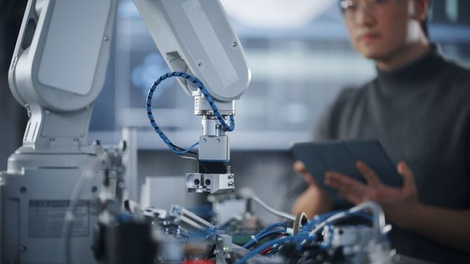 タブレット端末を手に、ロボットを操作している男性