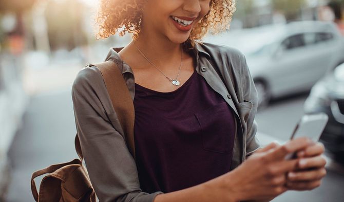 写真の女性がスマートフォンを使用
