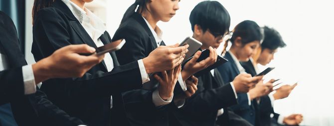 リクルートスーツに身を包んだ学生たちが面接の列に並んでいる