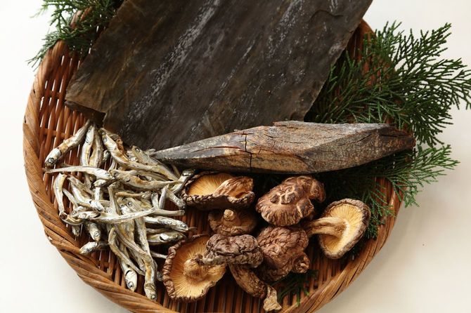 日本のだし。昆布、かつお節、煮干し、干し椎茸がかごに並べられている
