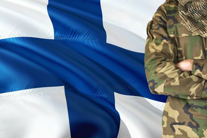 フィンランドの国旗と並ぶフィンランドの兵士